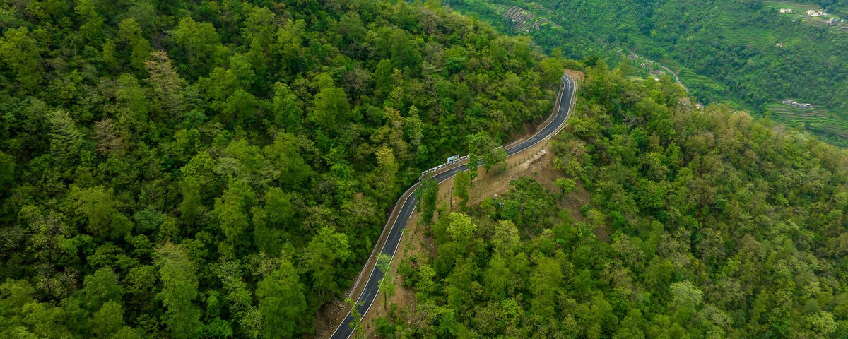 Aerial view of forested hills, representing ESG and BRSR reporting of CCTS and plantation